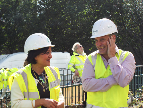 Mayor Rokhsana Fiaz OBE with Carpenters Project Director Nick Clough, Councillor John Whitworth in the background. The three wear high vis jackets and hard hats.